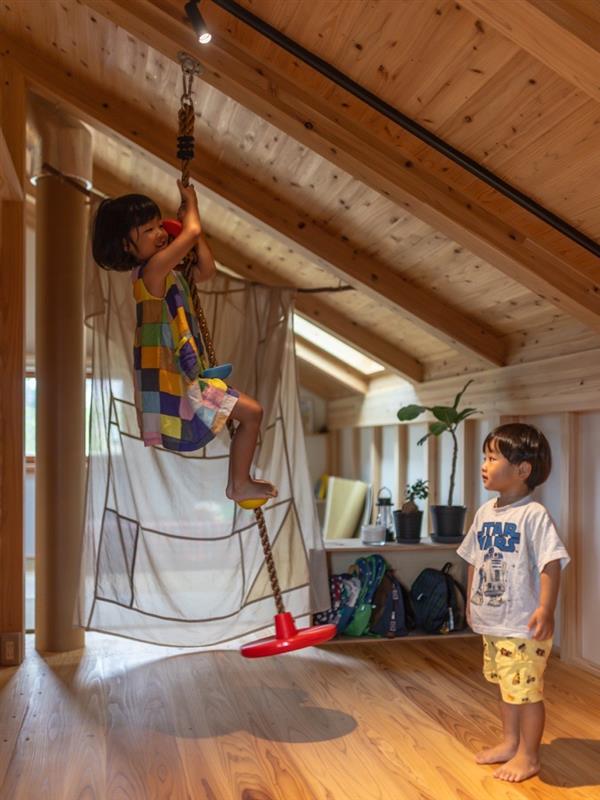 勾配天井を活用し子どもたちも自然素材の家を楽しんでいる写真です。