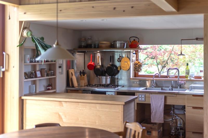 見せる収納の造作キッチンにある大開口サッシから、季節の移ろいが見えている写真です。