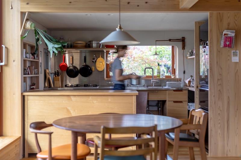 魅せる収納の造作キッチンに立ち準備をするお母さんの様子。