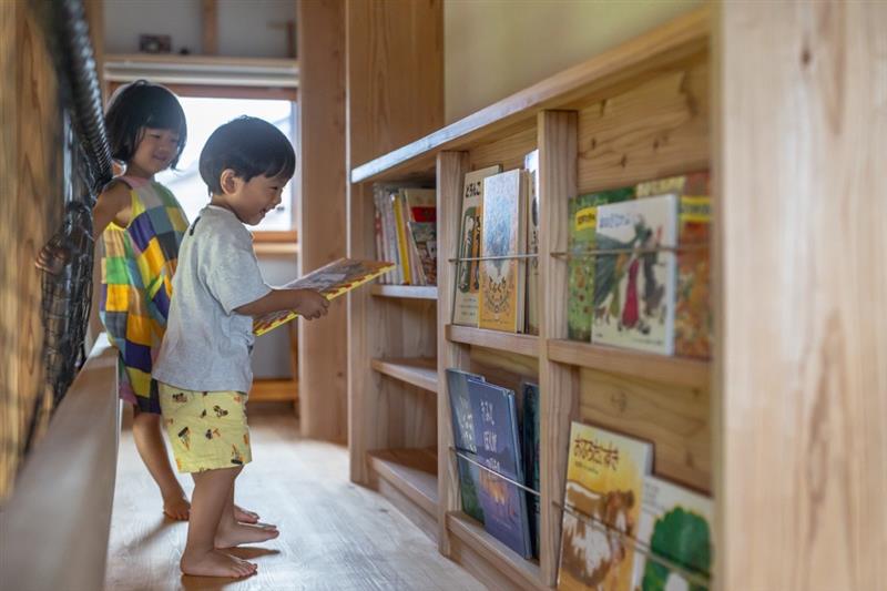 造作家具の本棚から本を選ぶ子どもの姿の写真です。
