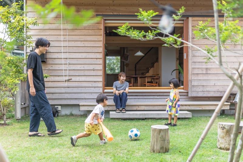 大開口サッシから中庭で遊ぶ子どもを眺めるお母さんの写真です。