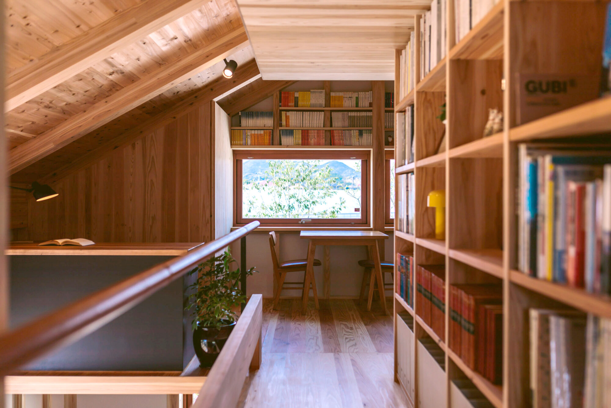 本棚にある勾配天井と木製サッシから外の景色がキレイな写真。